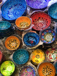 Vibrant bowls stacked softly, glowing with warm reds and cool blues, reflecting slow living charm.