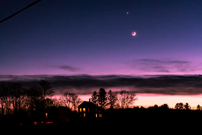 Twilight view of a villa glowing warmly under a starry sky.