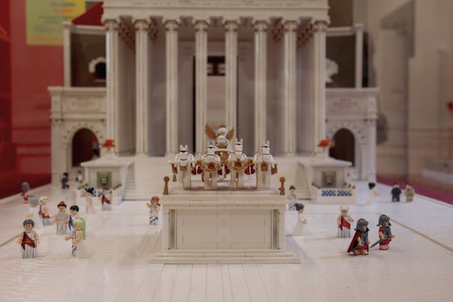 A detailed Roman military camp bustling with legionnaires preparing for battle under a fiery sunset.