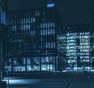 Modern urban real estate buildings illuminated subtly in a nighttime blue tone.