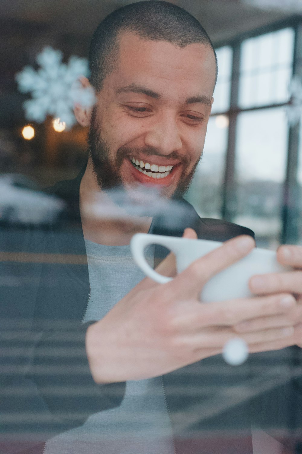 smiling man holding white ceramic mug