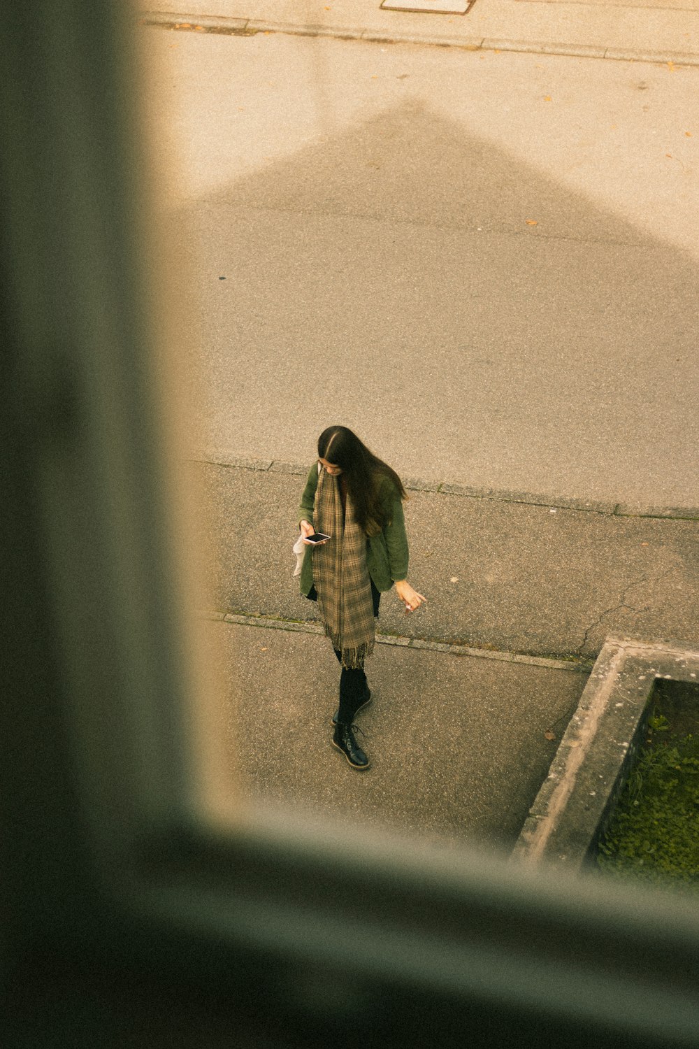 woman in brown coat and black pants walking on gray concrete road during daytime