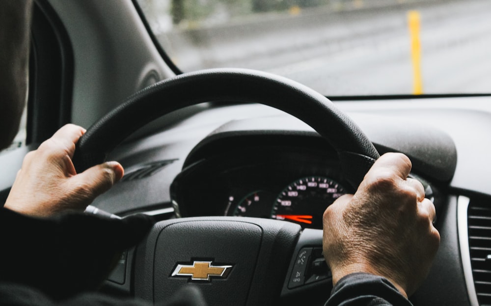 person driving black chevrolet car