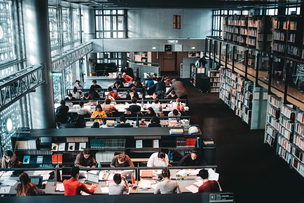 a group of people sitting at tables in a library