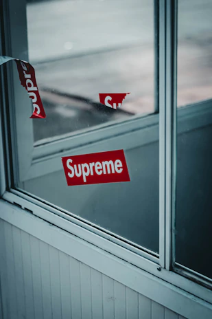 Side-by-side photos of a storefront window before and after applying branded adhesive film.