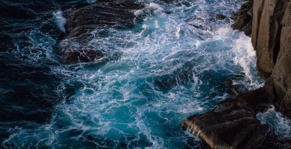 brown rock formation on body of water during daytime