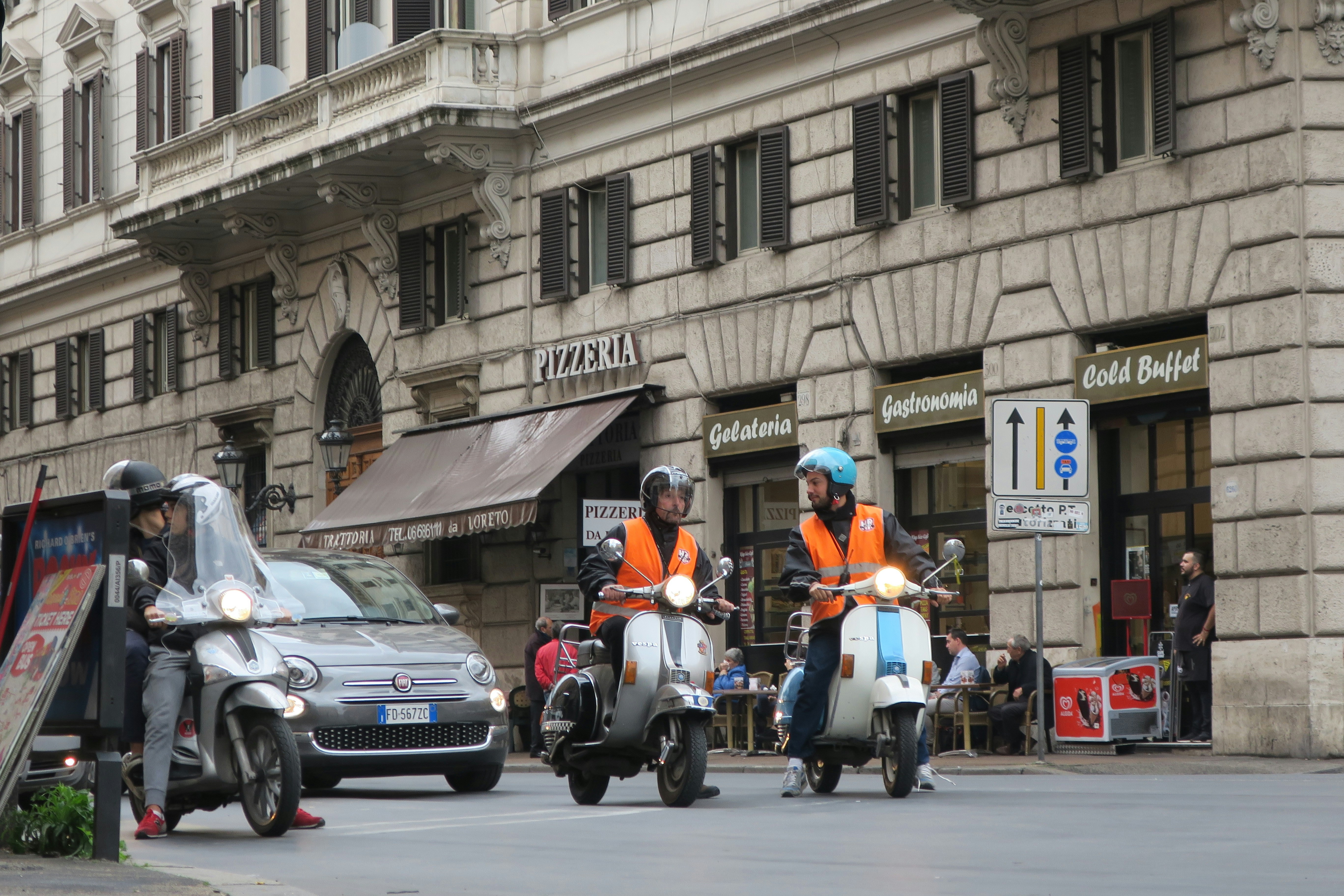 A couple of scooters Vespas in the street.