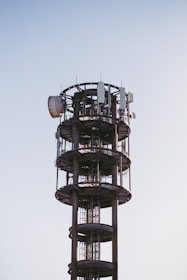 A modern telecommunications station with antennas against a clear sky.