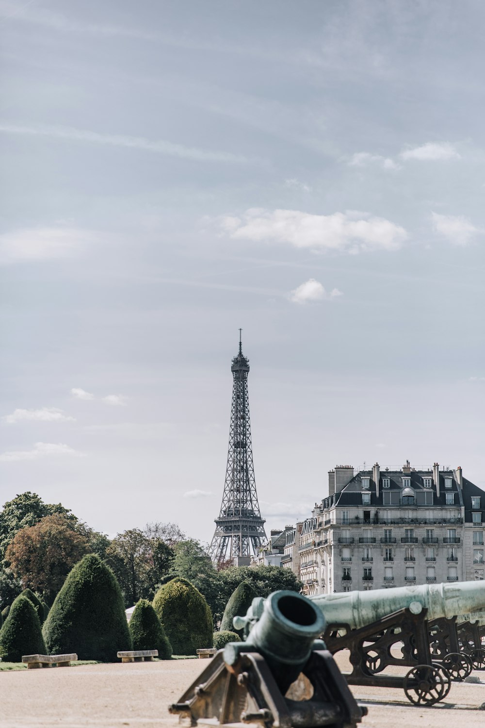 an old cannon is sitting in front of the eiffel tower