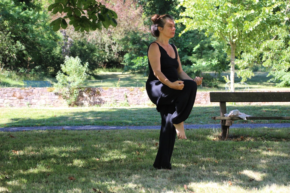 Woman In Black Tank Top And Black Pants Sitting On Brown Wooden
