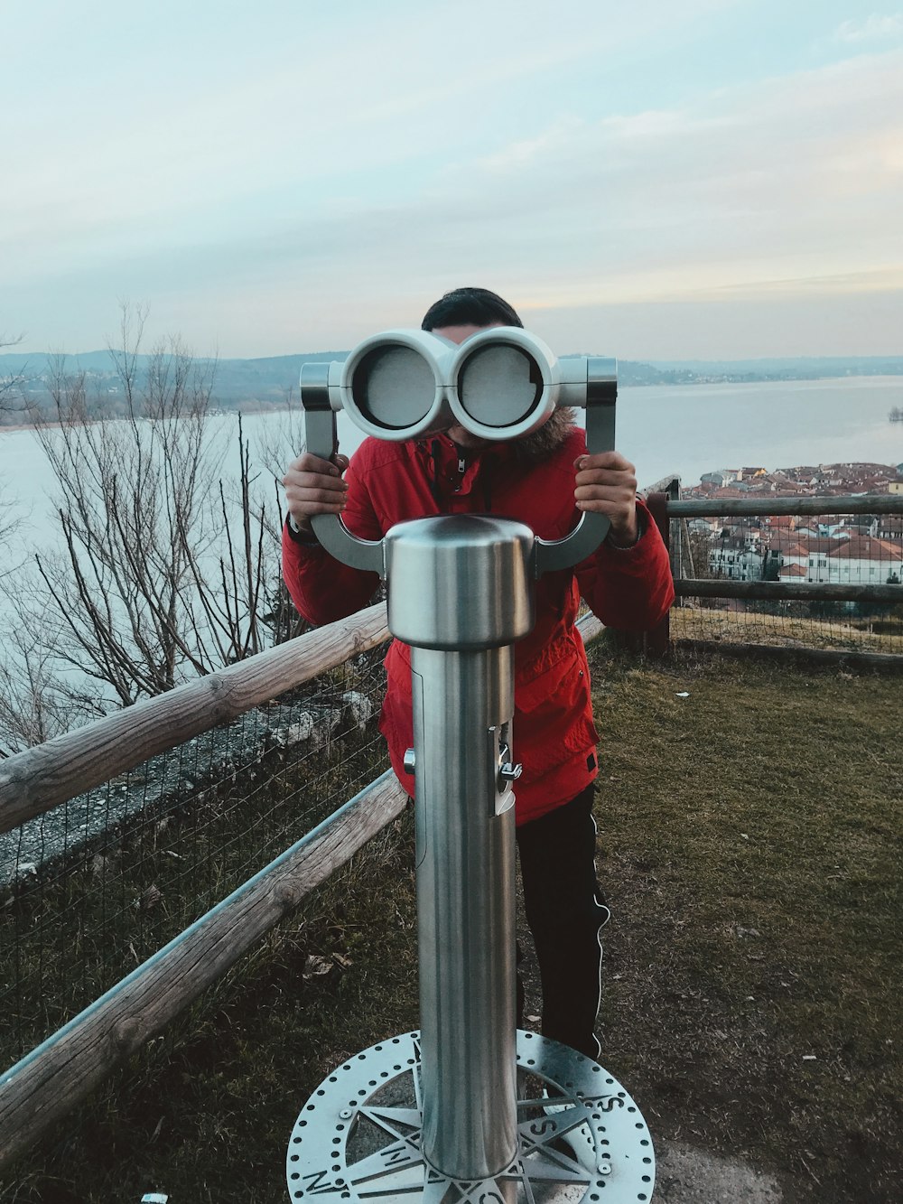 woman in red jacket using binoculars