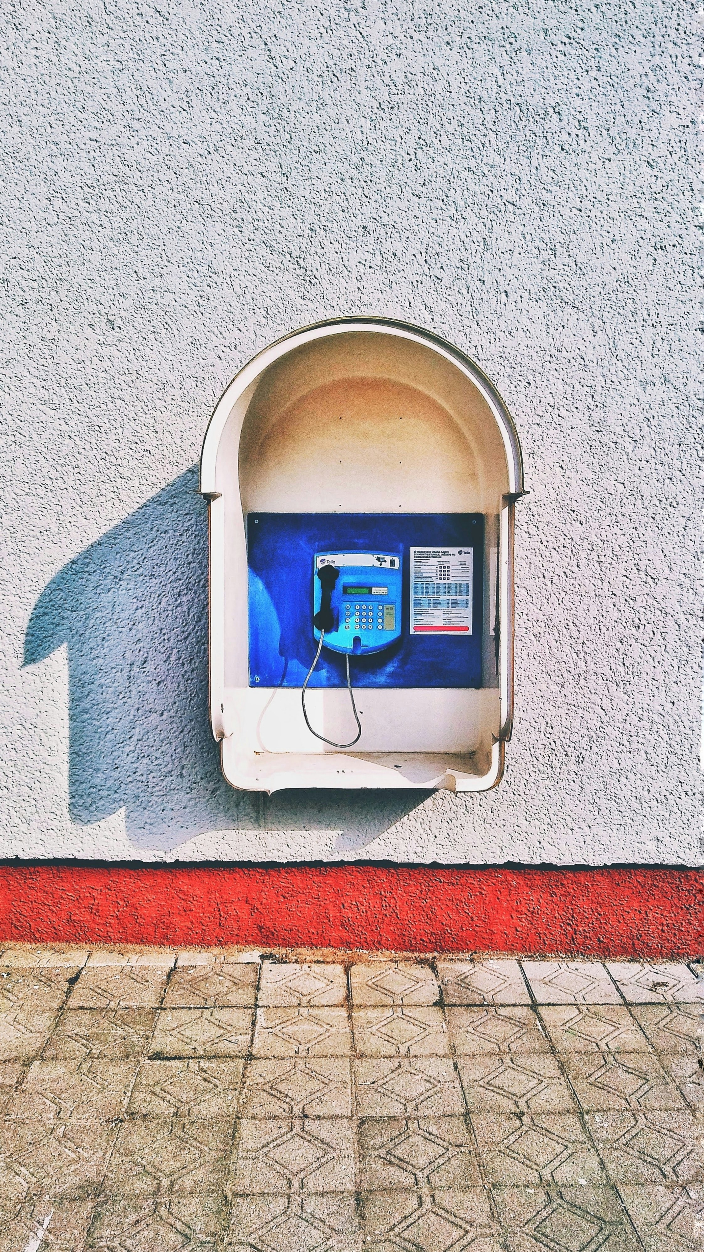 blue and white telephone on white wall