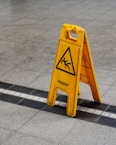 a yellow caution sign sitting on the side of a road