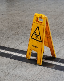 a yellow caution sign sitting on the side of a road