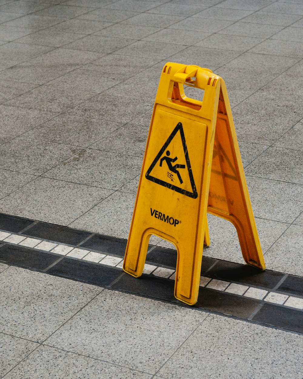 um sinal amarelo de advertência sentado na beira de uma estrada