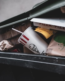 a trash can with a cup in it