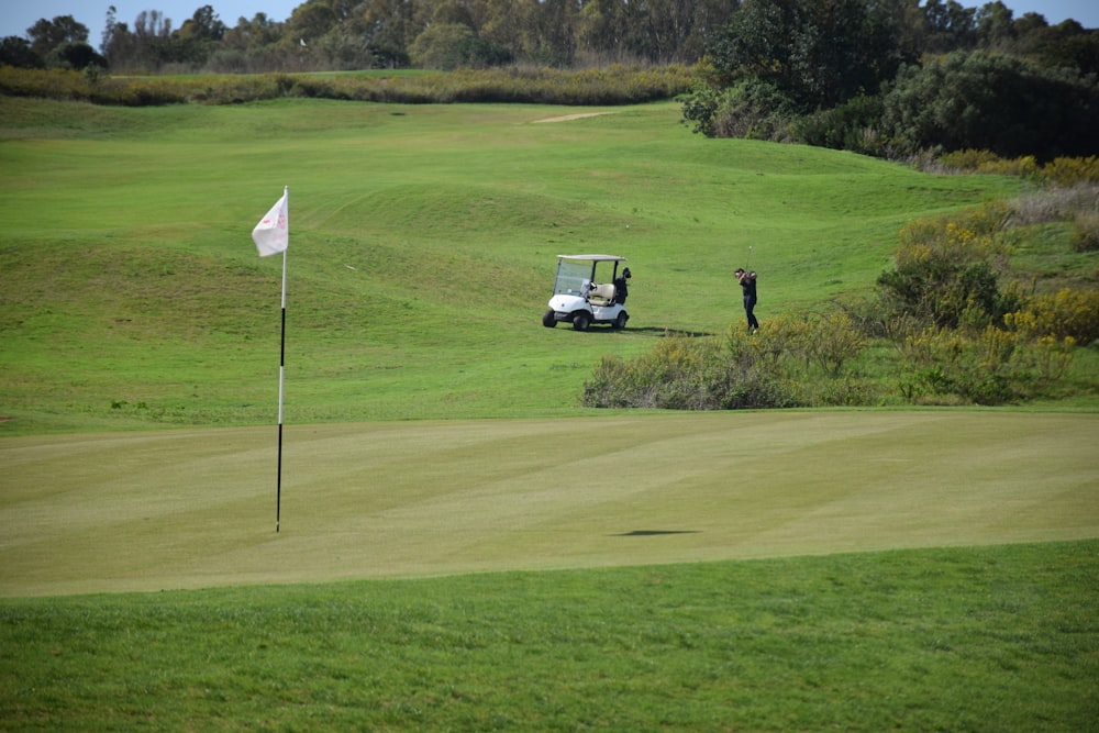 man in black jacket and pants standing on golf course during daytime