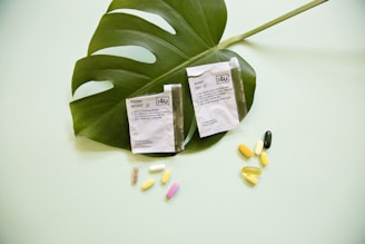 white and yellow medication pill on green leaf