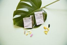 white and yellow medication pill on green leaf
