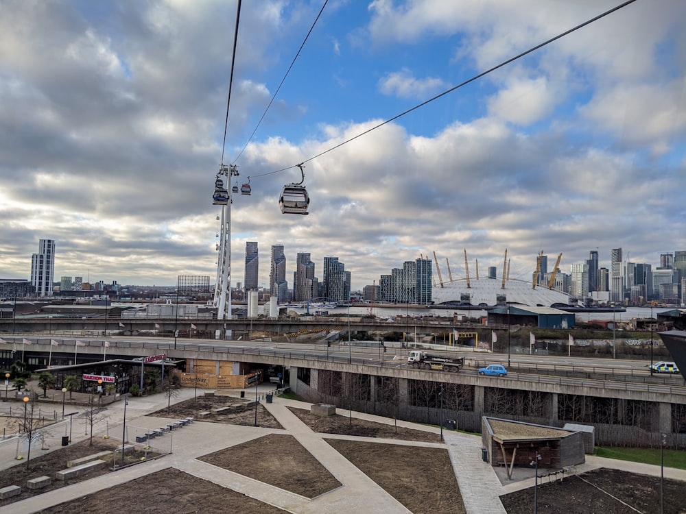 white and black cable cars on gray concrete road under white clouds and blue sky during