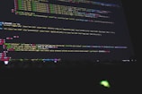 Colorful code is displayed on a computer screen, featuring a mix of HTML and CSS elements with syntax highlighting. The text is organized in lines and the colors indicate different tags and attributes, including classes and style properties.