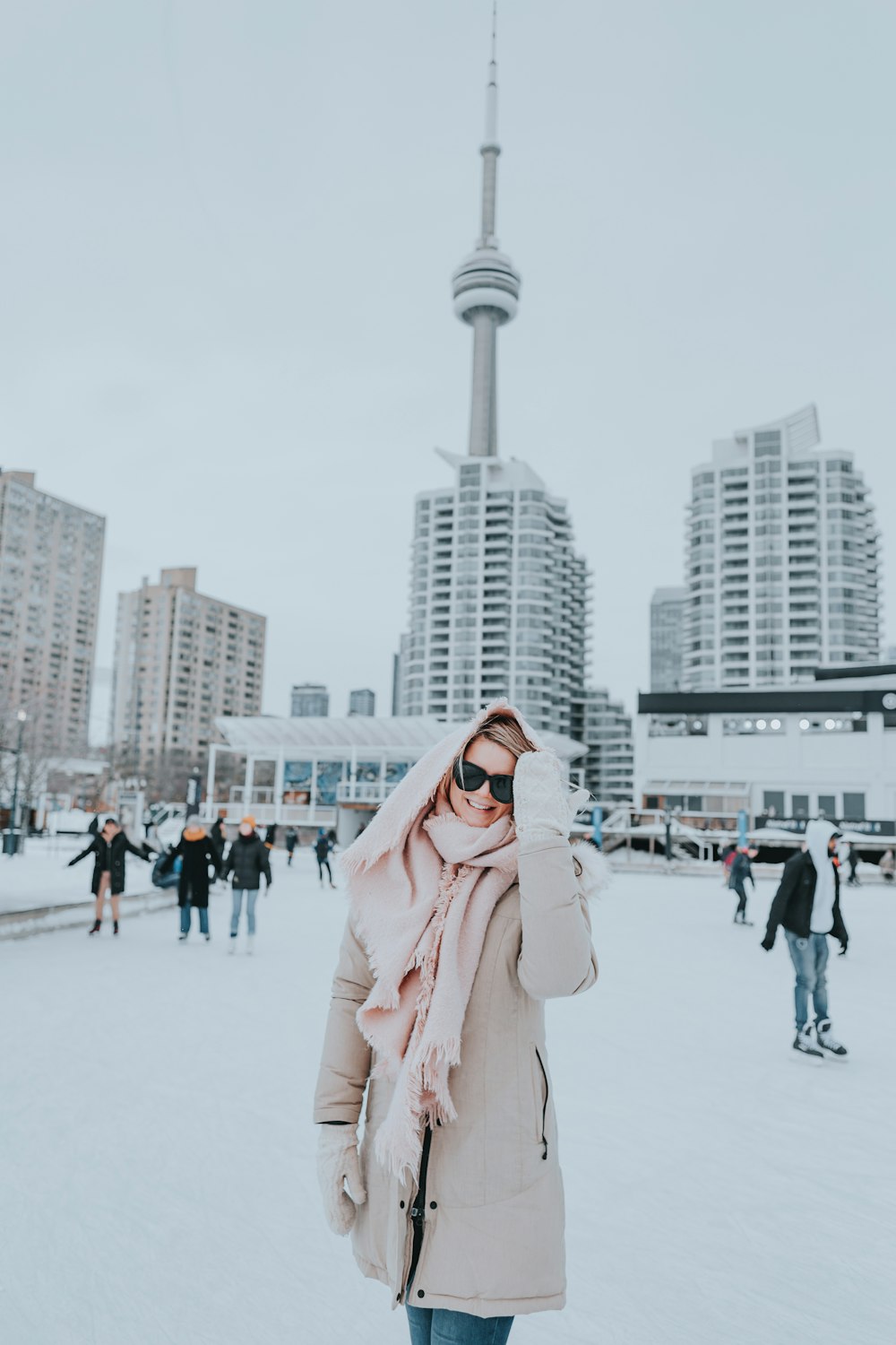 a woman standing in the snow in front of a tall building