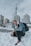 a man kneeling in the snow with a backpack