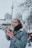 a man standing in the snow looking at his cell phone
