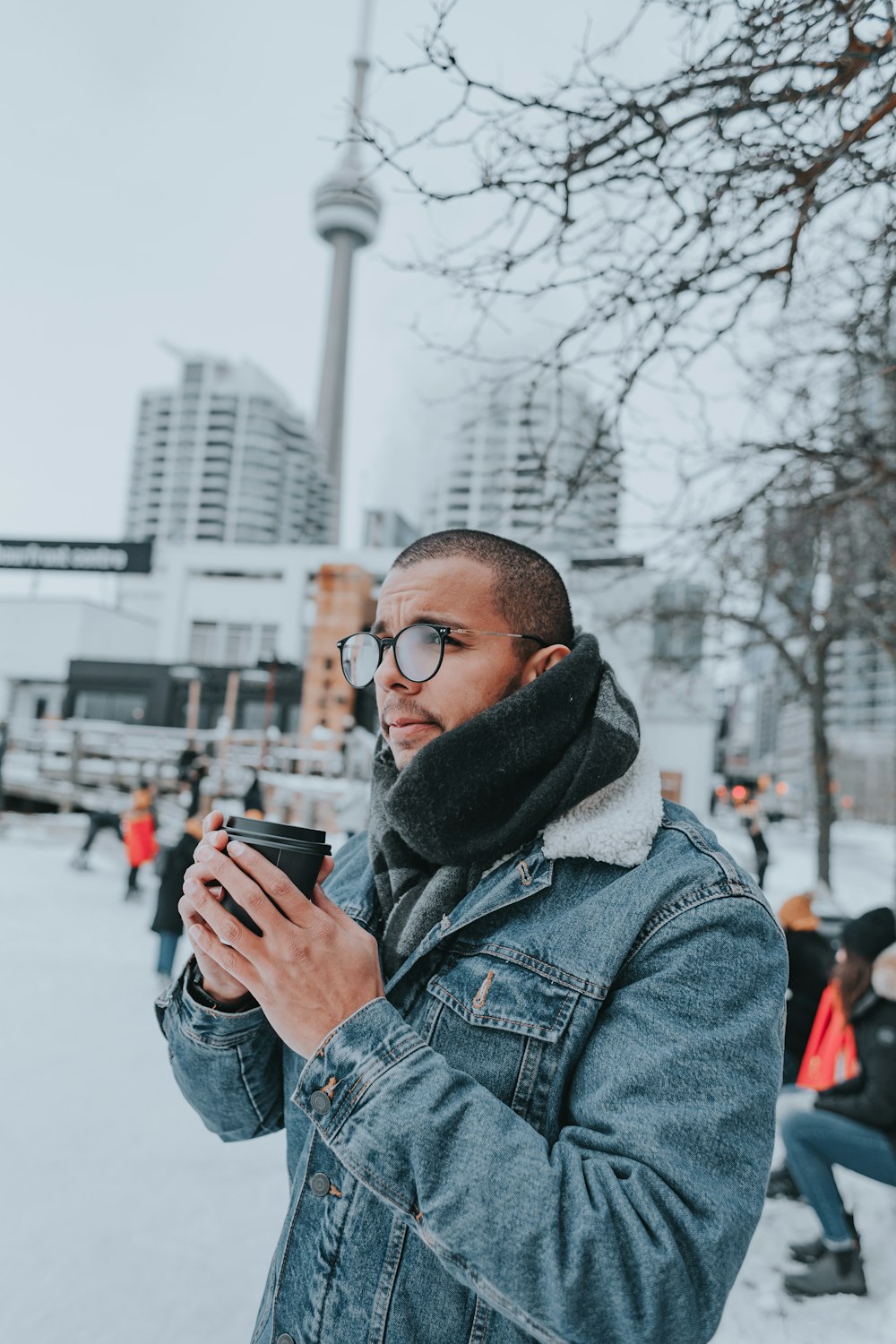 a man standing in the snow looking at his cell phone