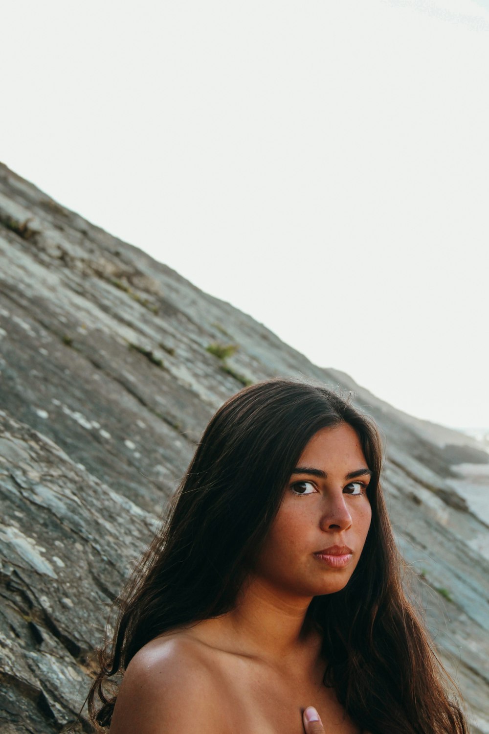 a woman standing in front of a rocky cliff