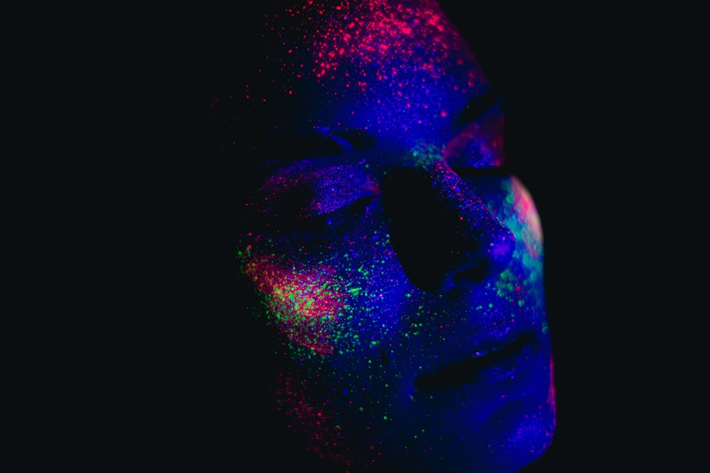 a woman's face covered in colored powder