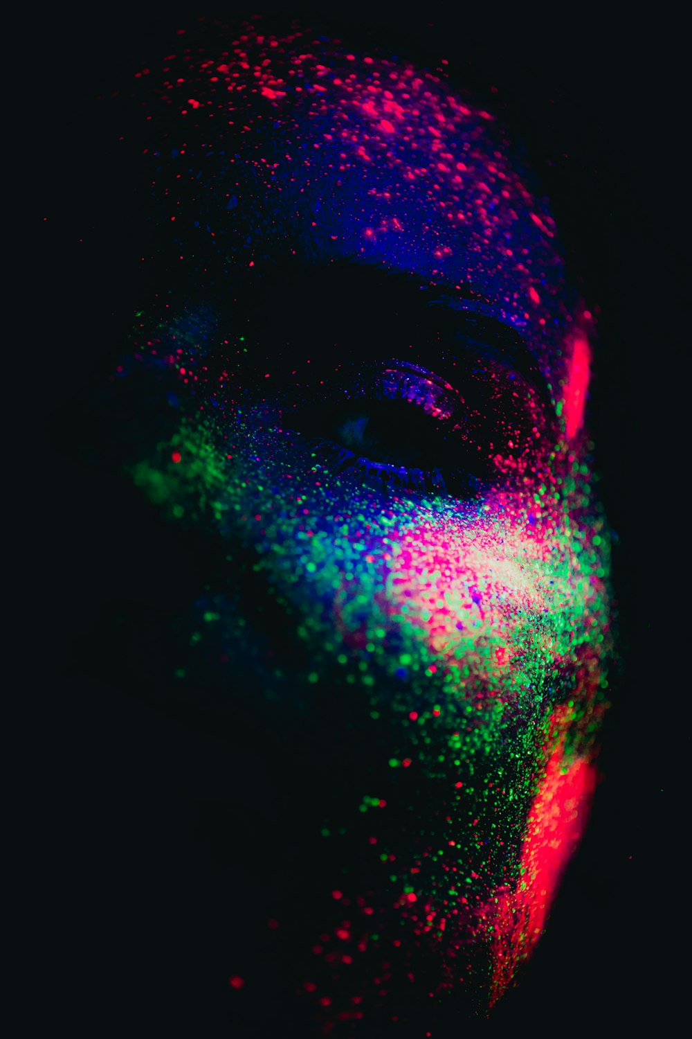 a man's face covered in colored powder