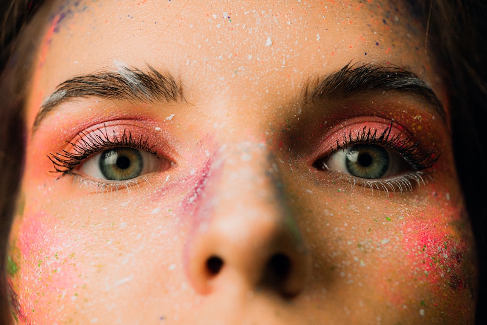 a close up of a woman's face with colorful makeup