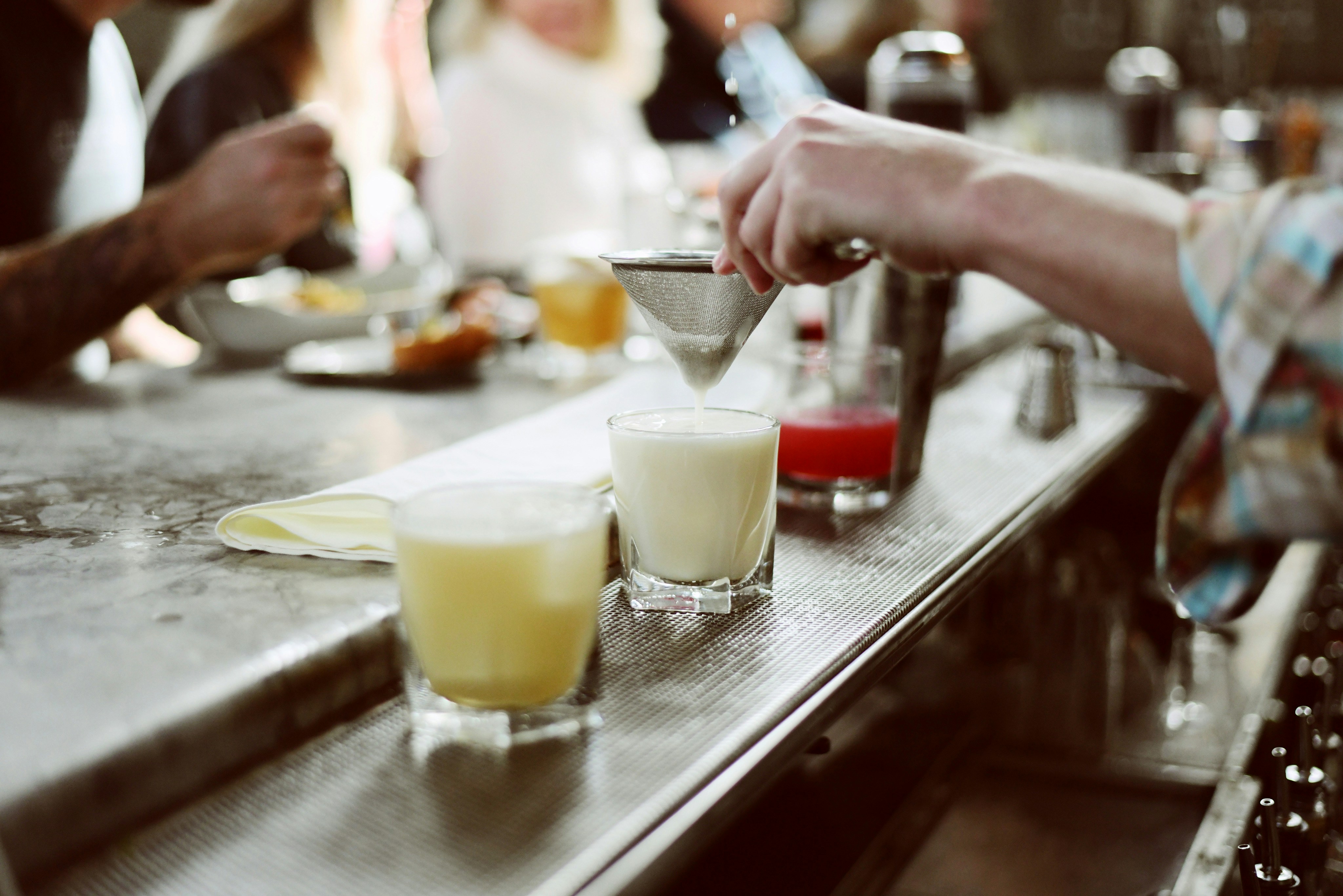 a person pours a drink at a bar