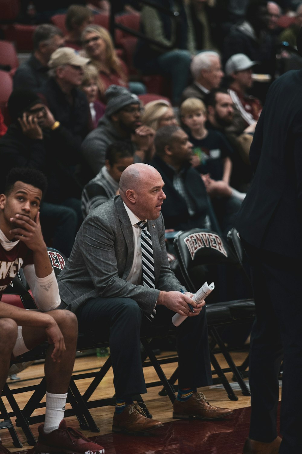 a group of men sitting next to each other on a basketball court