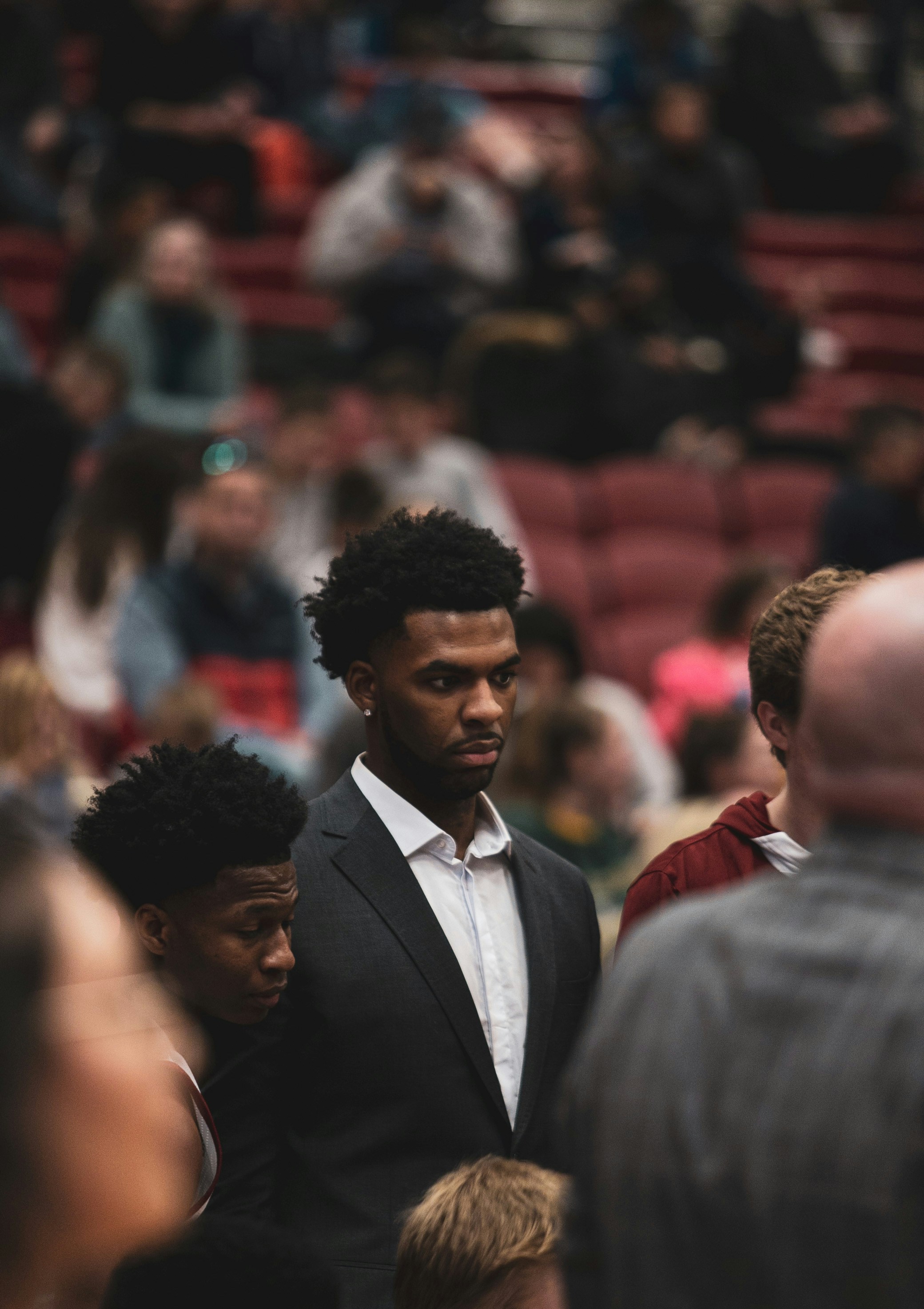A man in a suit standing in front of a crowd of people photo – Free ...