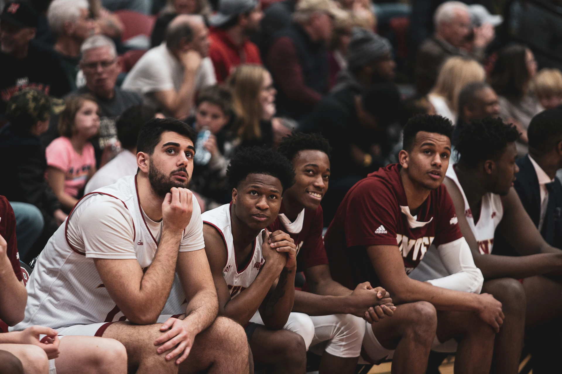 a group of young men sitting on top of a basketball court