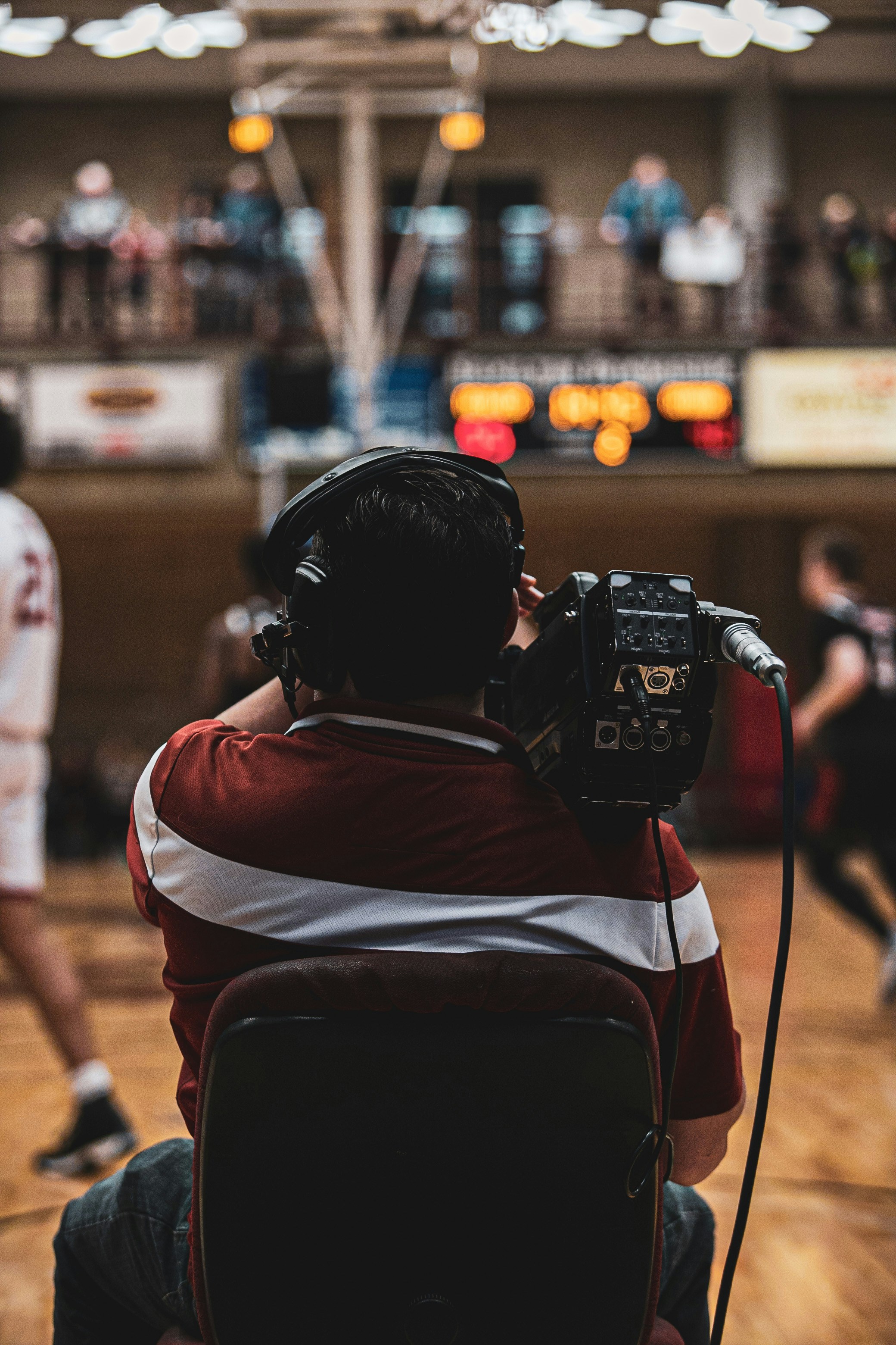 a man sitting in front of a camera on top of a hard wood floor