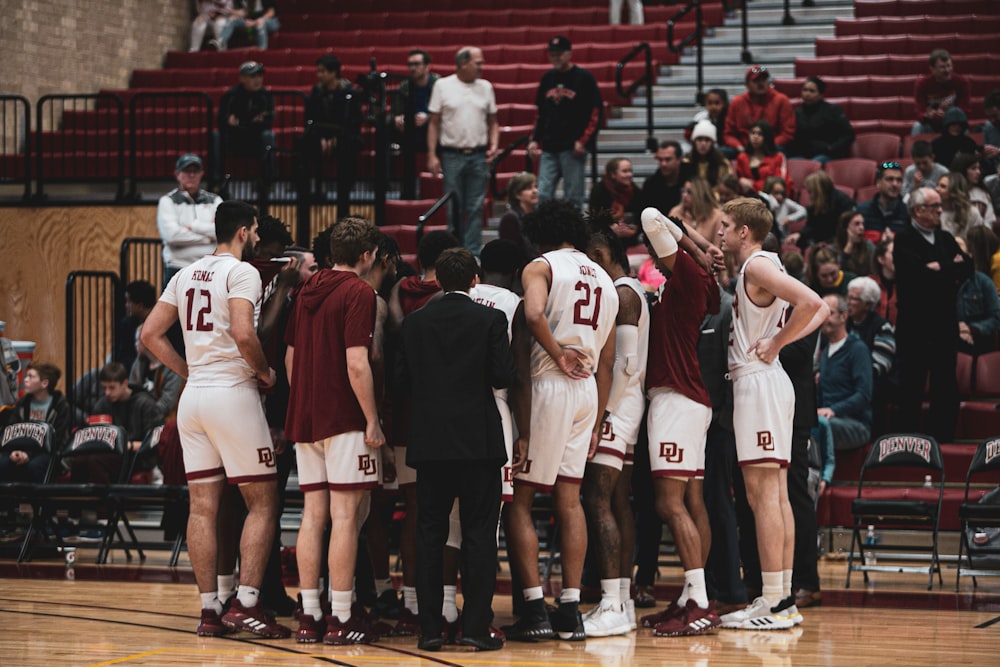 a group of men standing next to each other on a basketball court