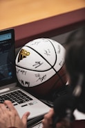 A U.S. college coach reviewing athlete profiles on a laptop.