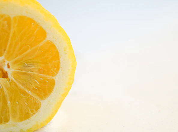 Close-up of a vibrant lemon gelato scoop with fresh lemon slices and a rustic wooden background.