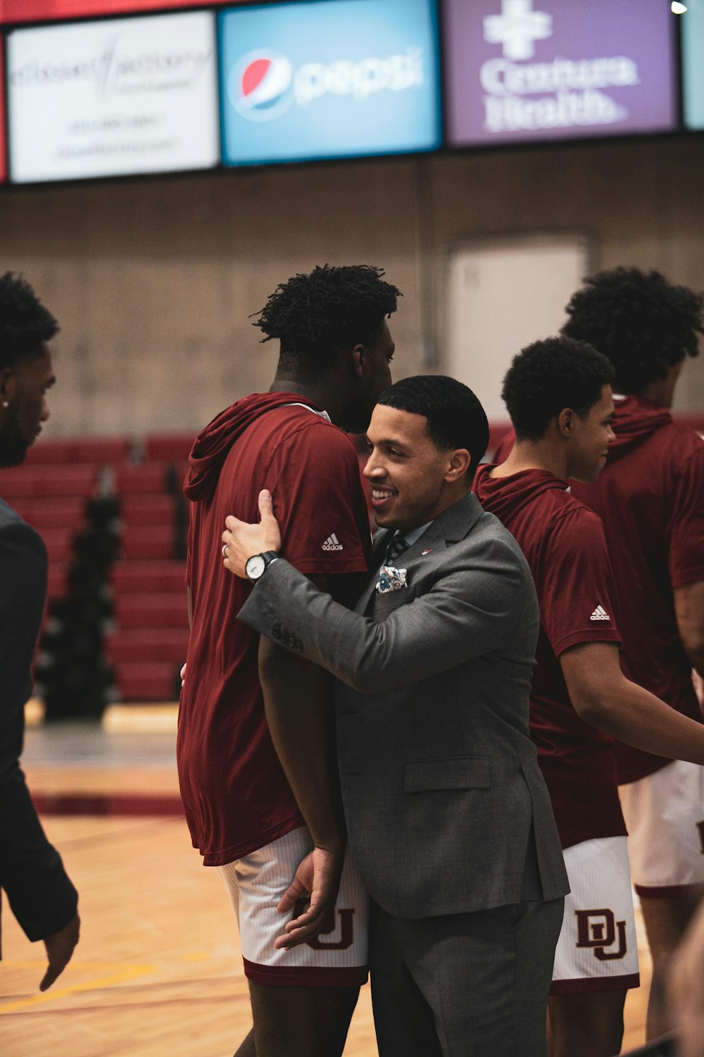 a man in a suit and tie standing on a basketball court