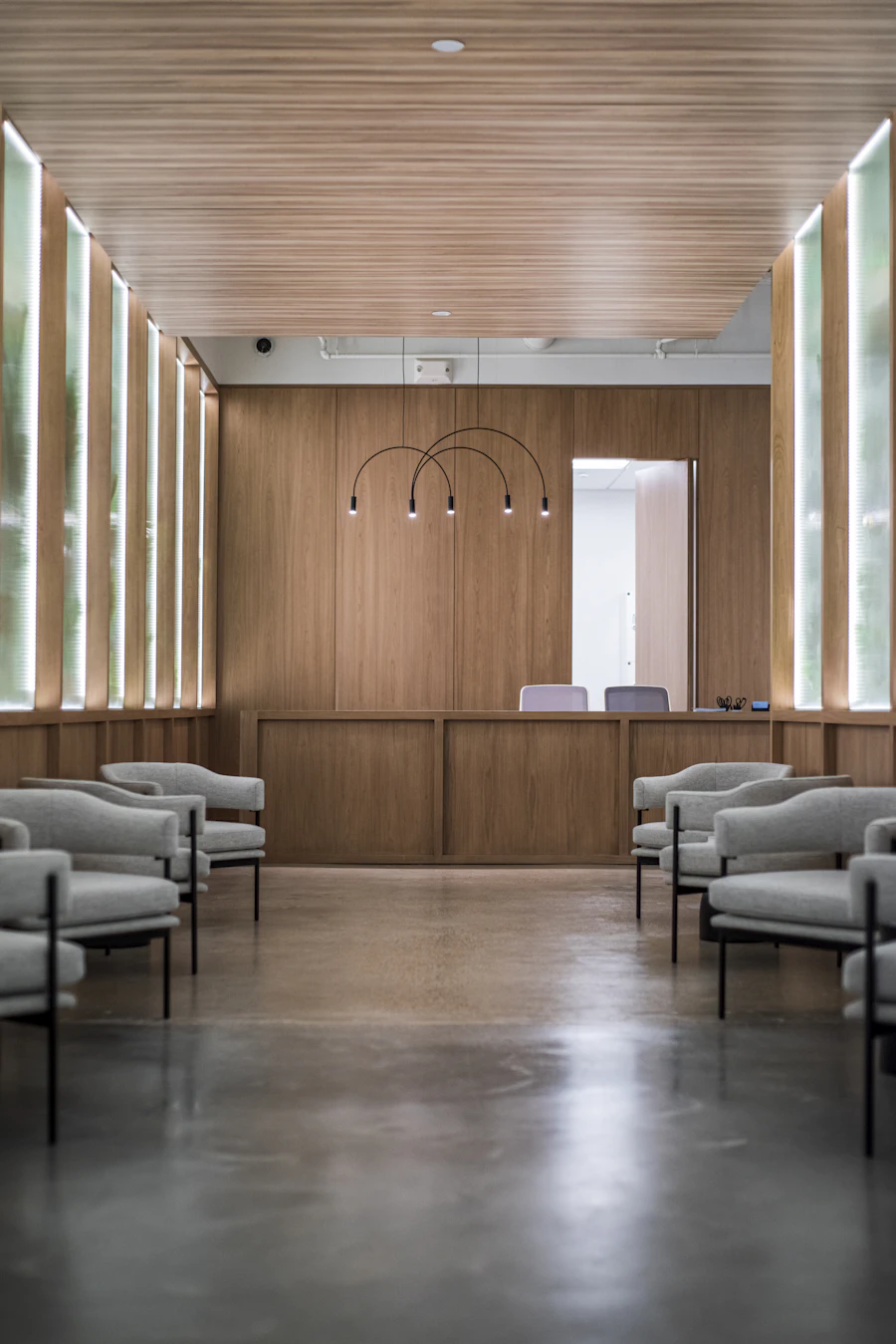 Waiting area with grey sofa chairs on a wooden floor