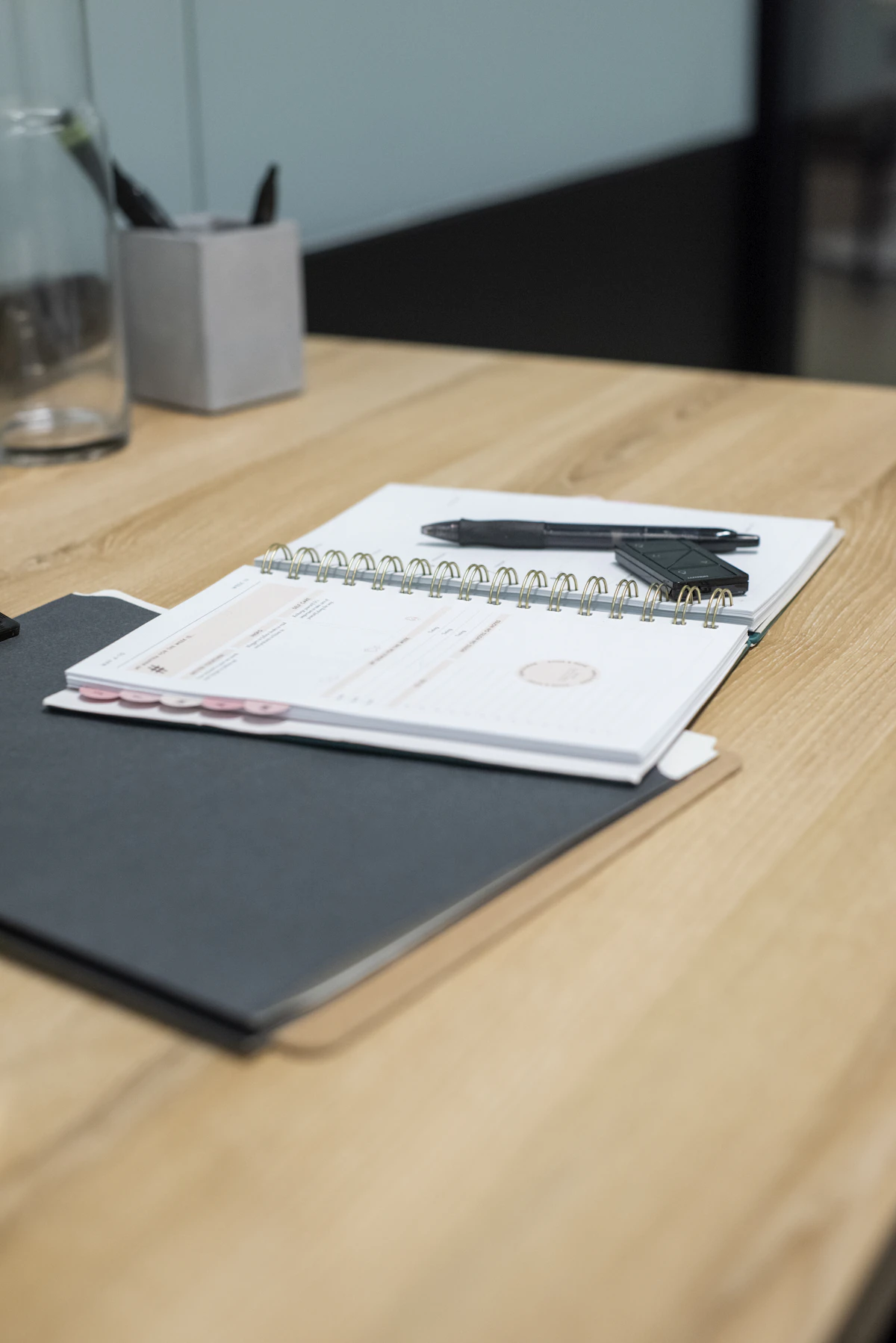 An open notebook and pen on a wooden desk in a quiet consulting room