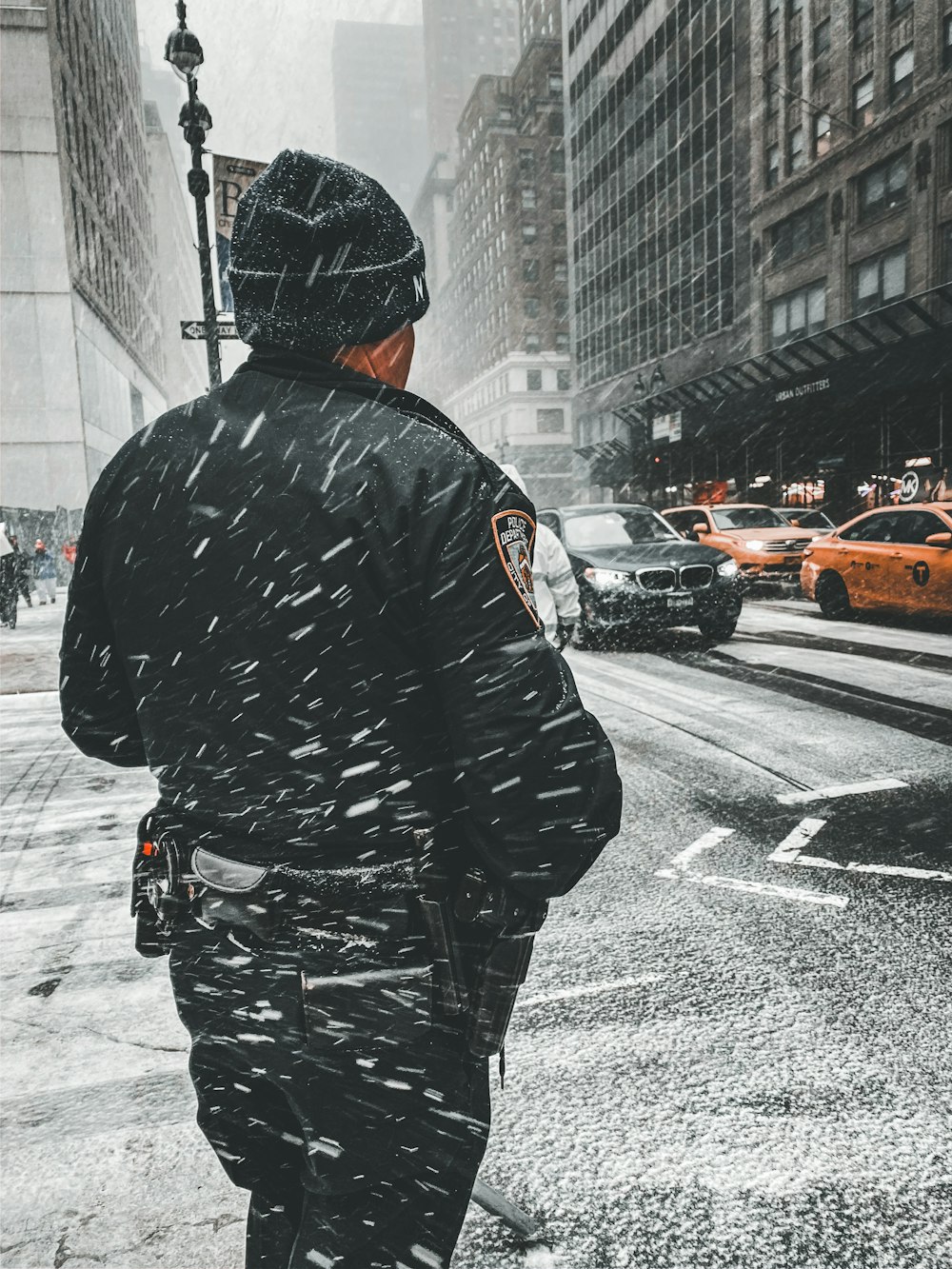 man in black and white jacket walking on street during daytime