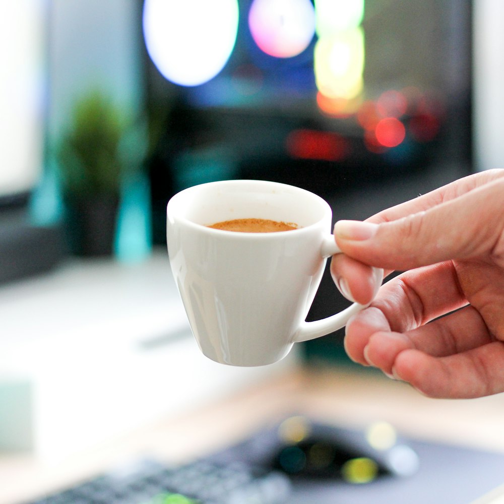 person holding white ceramic mug