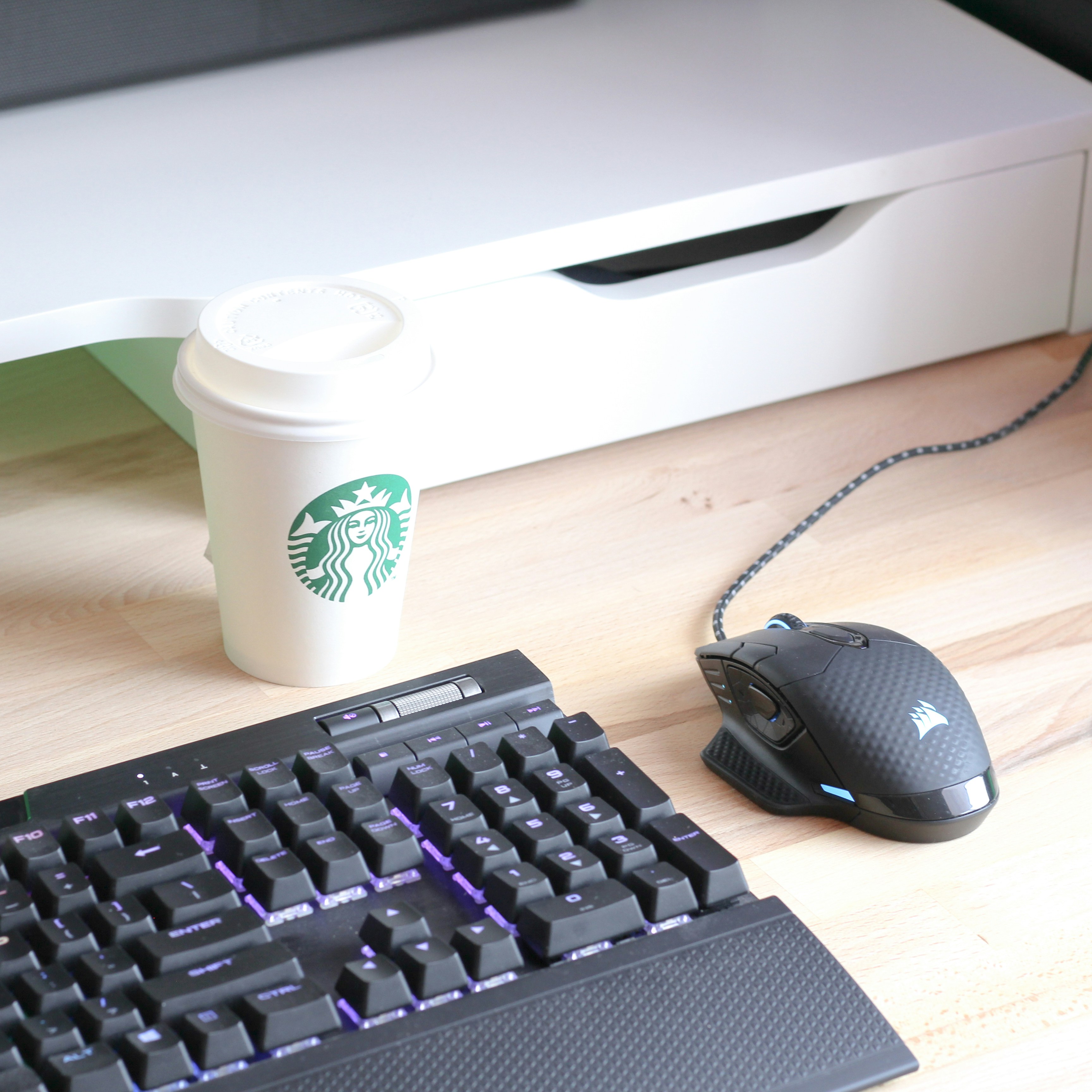 black computer keyboard beside white and green disposable cup