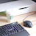 Close-up of a sleek aluminium cup holder clamped firmly to a modern wooden desk beside a gaming keyboard.