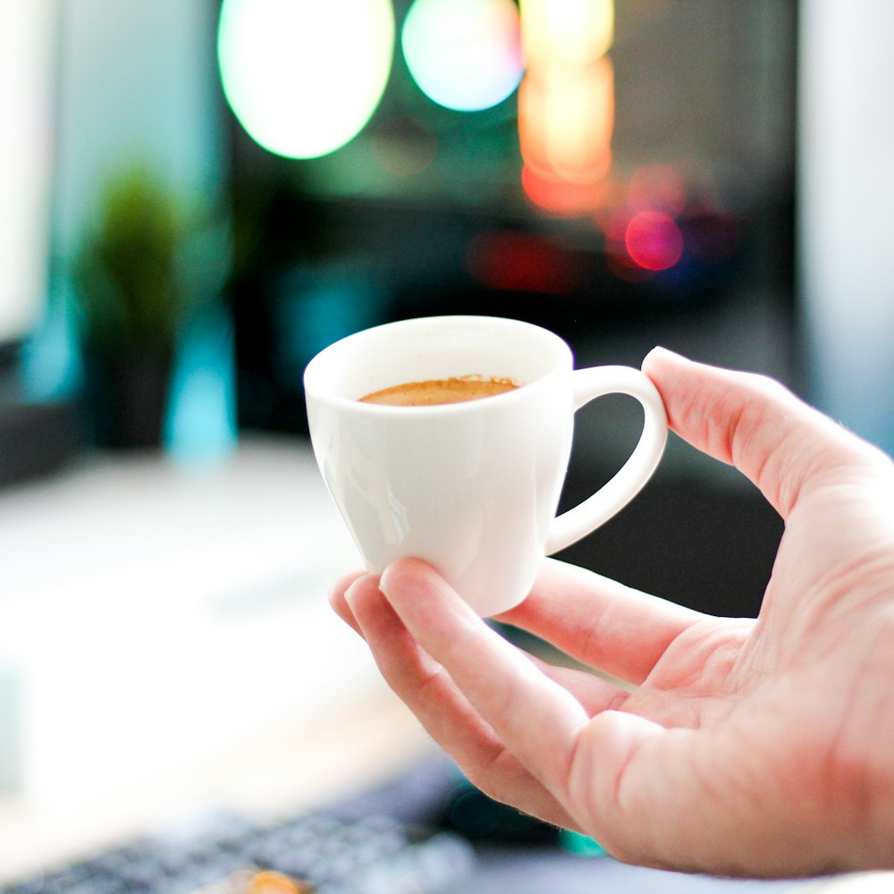 person holding white ceramic mug