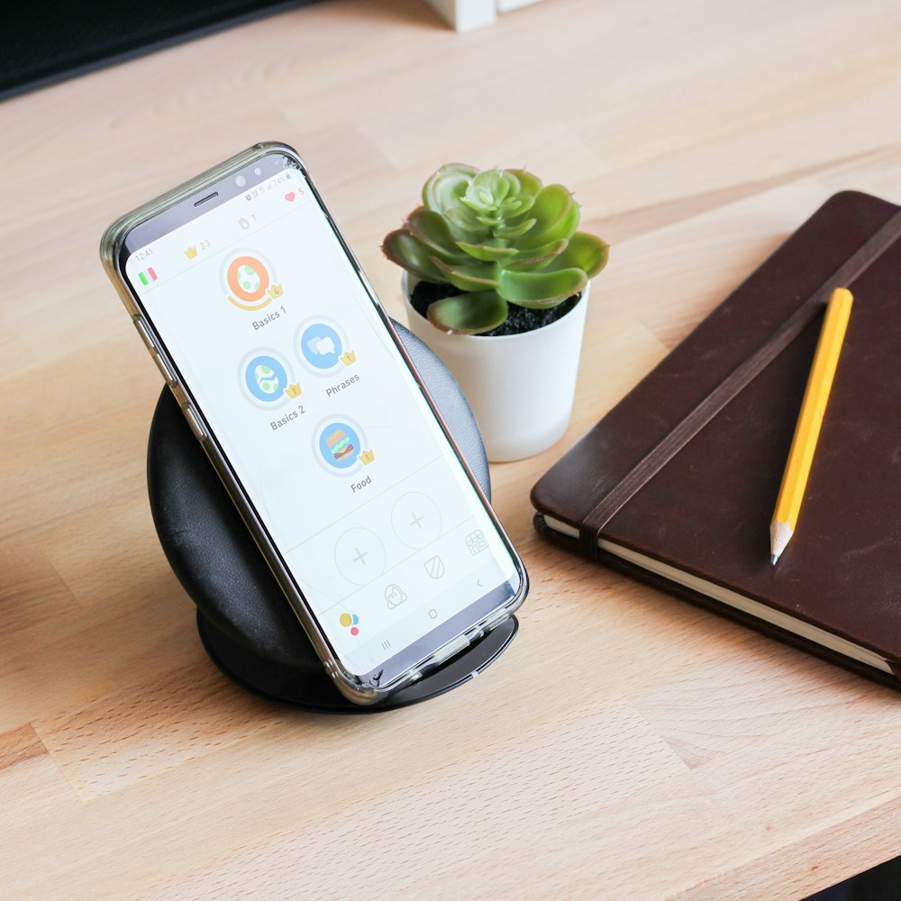 white remote control on black leather tablet computer case